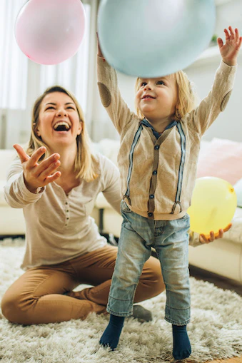 Woman and boy playing with colorful balloons