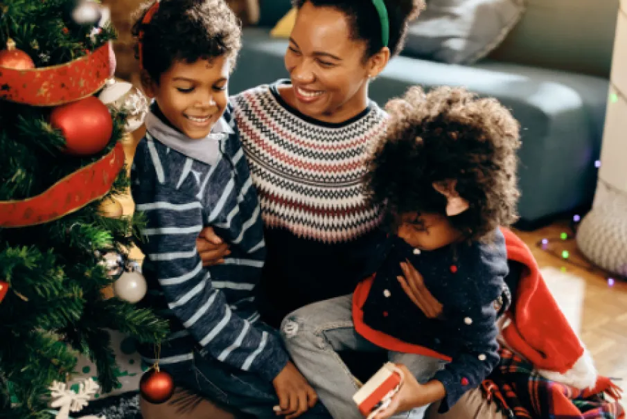 Family celebrating Christmas by the tree with reindeer antlers