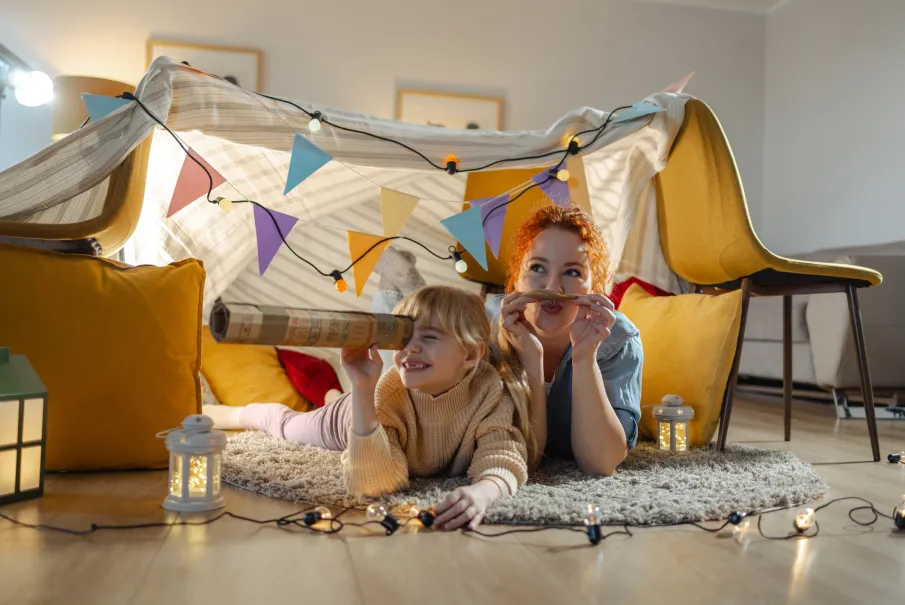 Family playing in a homemade fort with colorful decorations