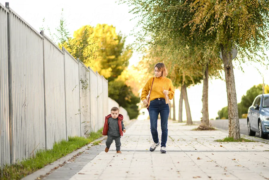 Mother and toddler walking on a sunny pathway
