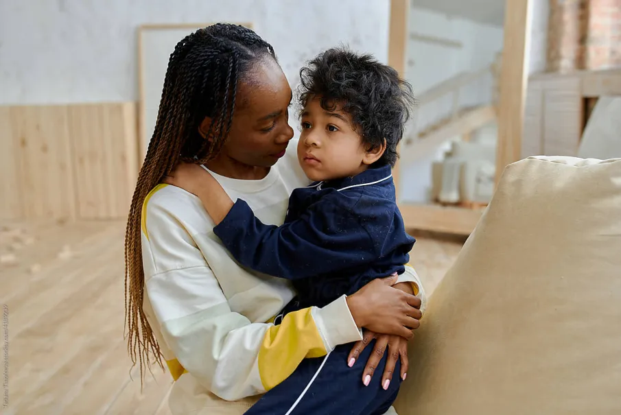Mother holding her young child in a cozy living room
