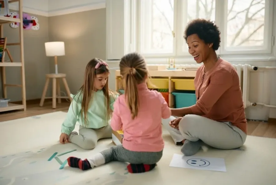 Children engaged in a playful activity with a teacher in a bright classroom setting
